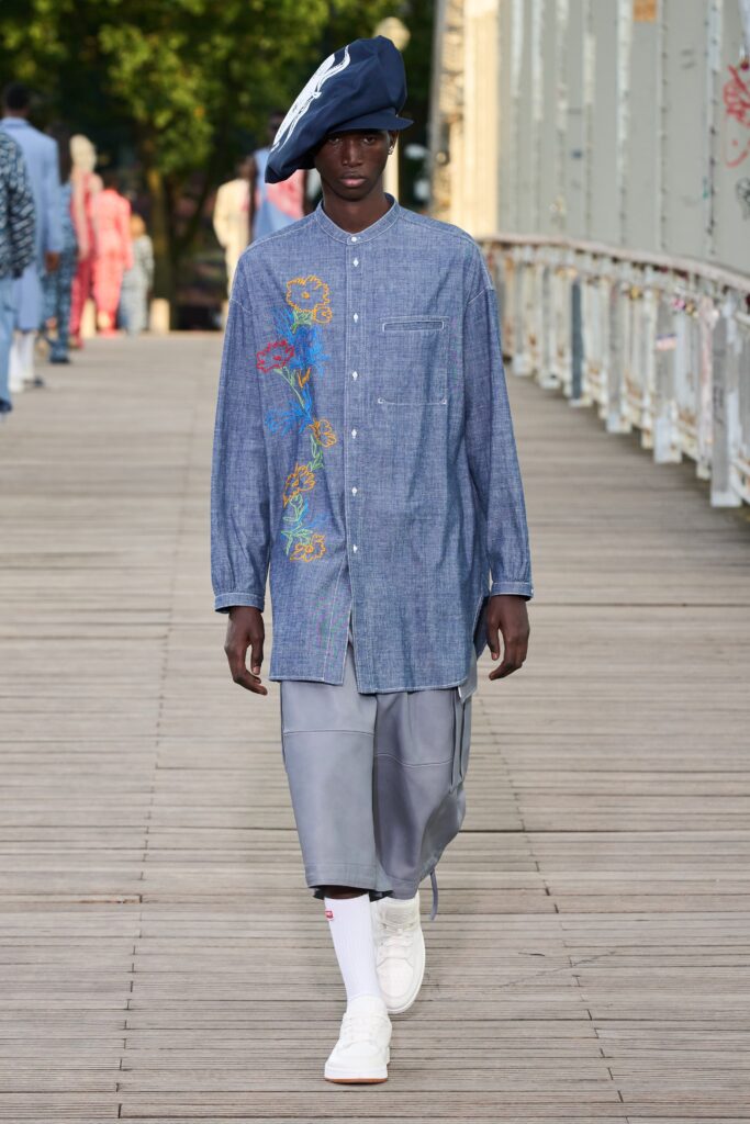 A relaxed blue long-sleeve shirt with embroidery paired with gray wide-leg pants.