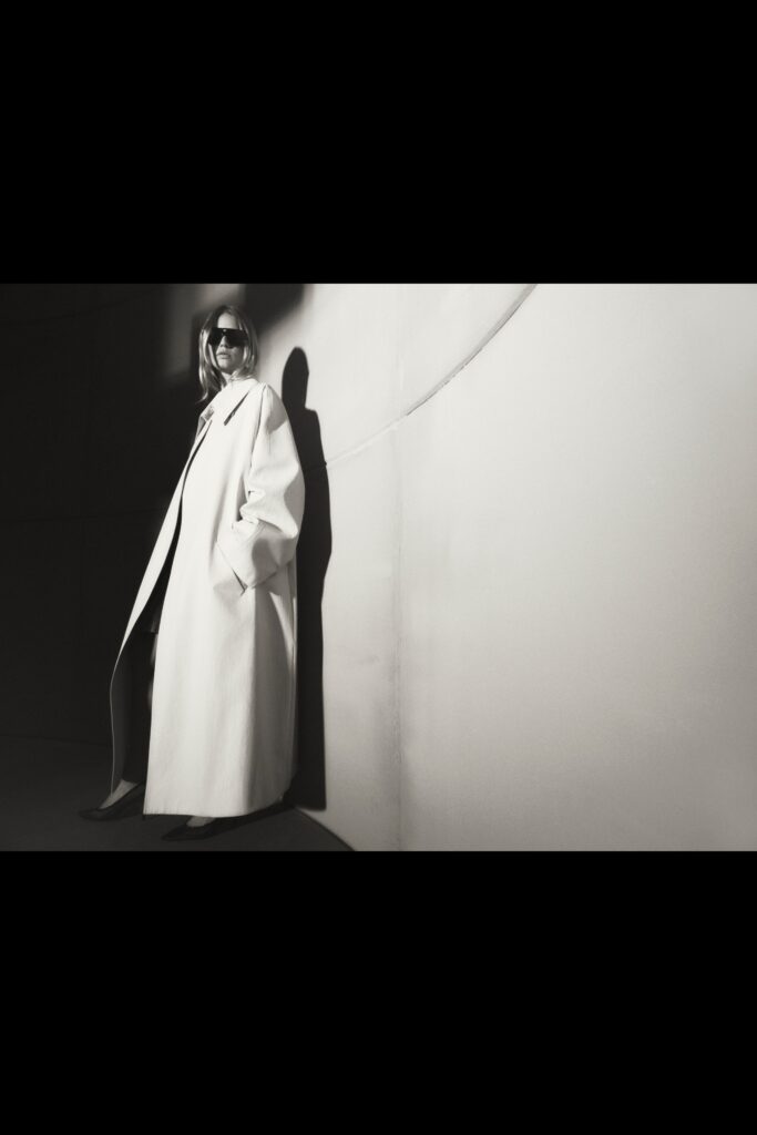 An oversized white coat with long sleeves and a collared design, perfect for a chic look.