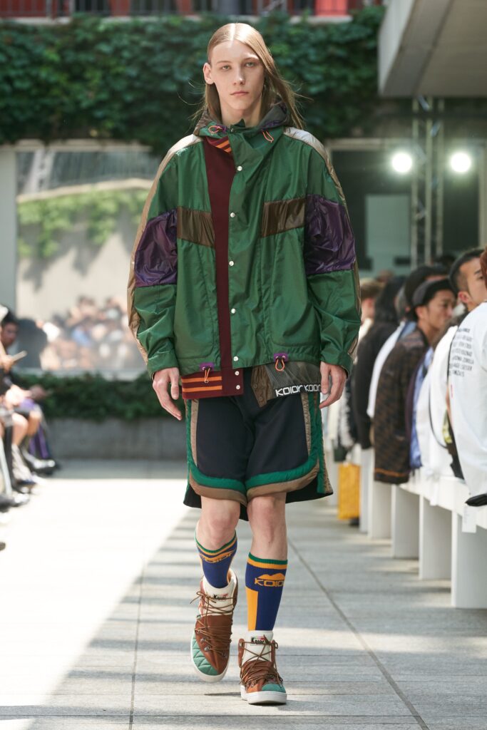 A relaxed fit color-blocked green jacket paired with matching shorts, showcasing a vibrant streetwear style.