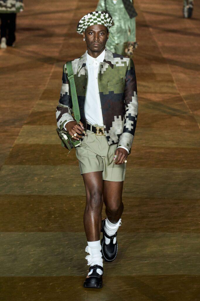 A fitted camouflage jacket with long sleeves and collared neckline paired with fitted shorts.