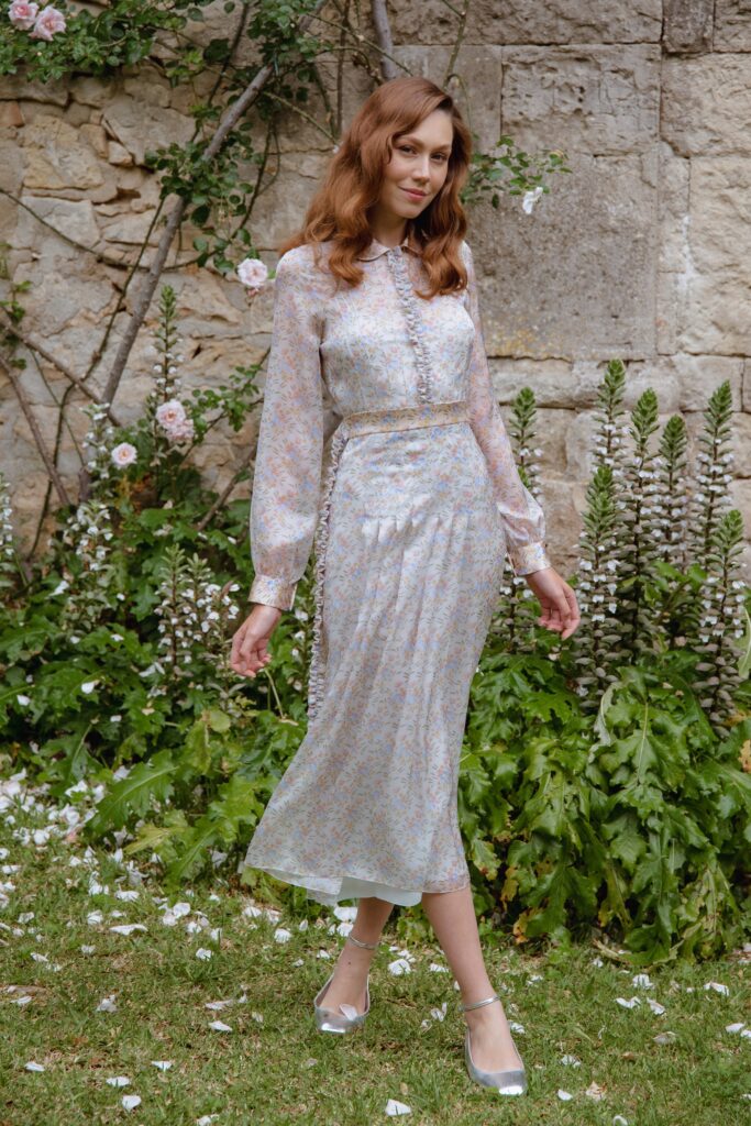 A fitted multicolor silk dress with long sleeves, a collared neckline, and pleated detailing.