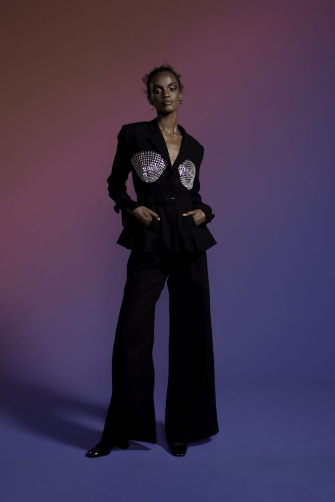 A fitted black jacket with a collared neckline and wide-leg pants, showcasing a stylish silhouette.