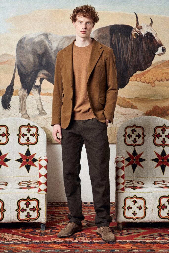 A fitted brown cotton blazer paired with straight-leg black pants.