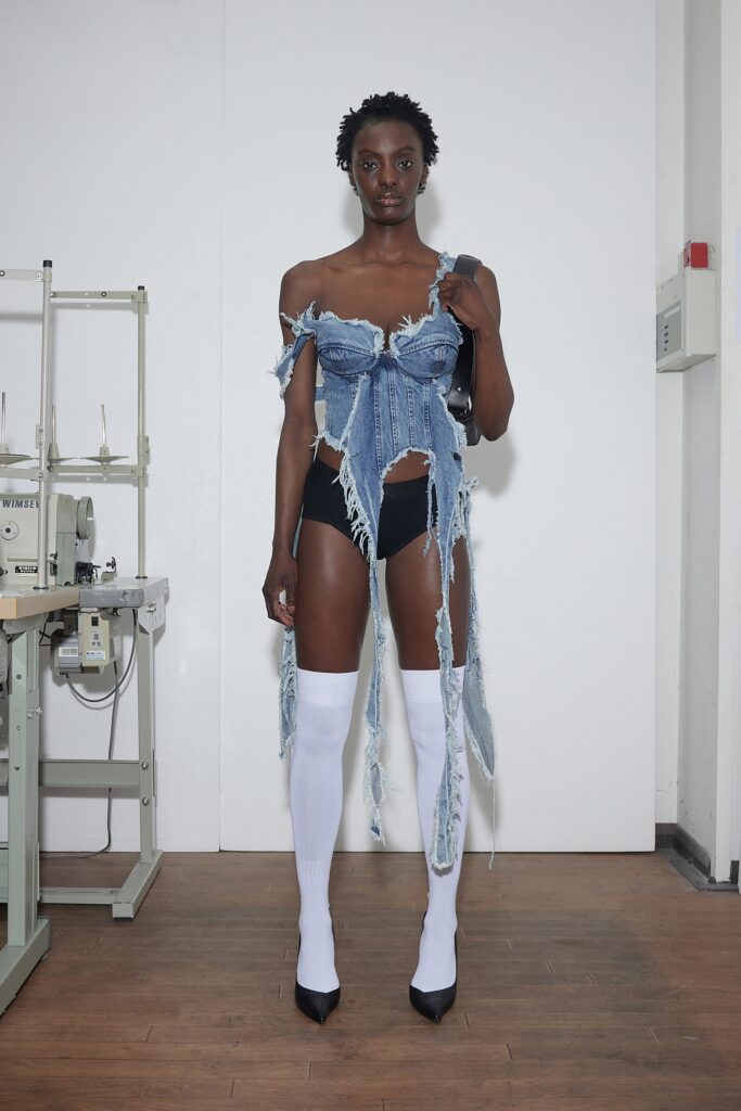 A fitted strapless blue denim dress with fringed detailing for a bold fashion statement.