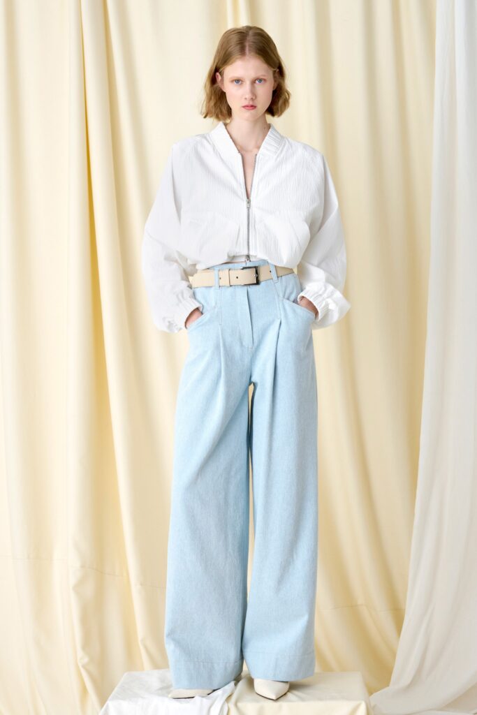A relaxed white long-sleeve collared shirt paired with blue wide-leg pants.