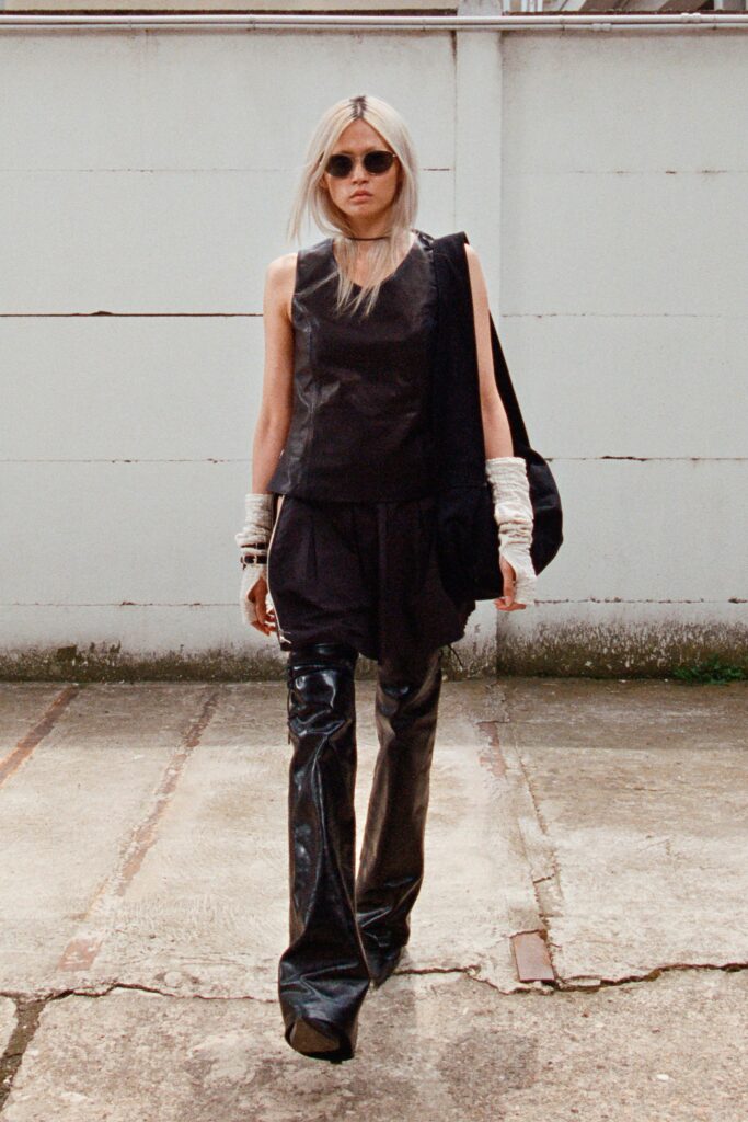 A fitted black leather sleeveless top paired with fitted black leather pants, creating a sleek silhouette.