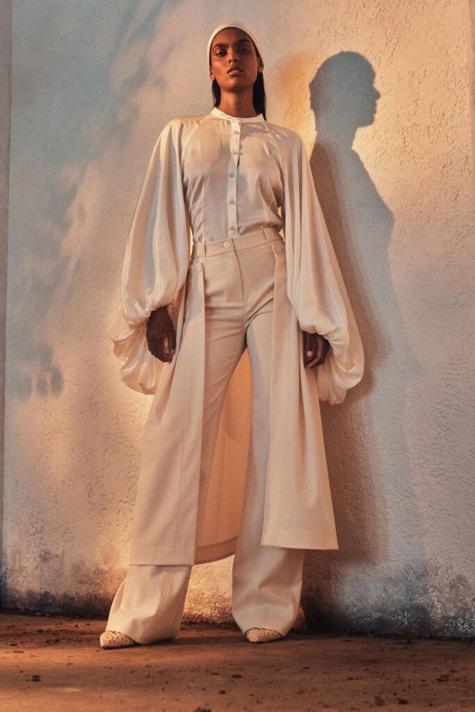A fitted white silk blouse with long sleeves and wide-leg pants for a chic look.