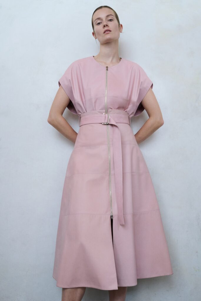 A fitted pink leather dress with short sleeves, a collared neckline, and an A-line silhouette.