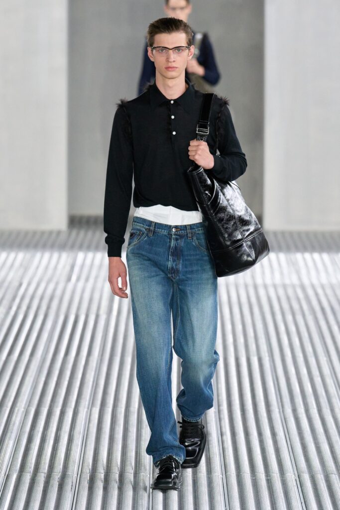 A relaxed black long-sleeve collared shirt paired with straight-leg blue denim pants.