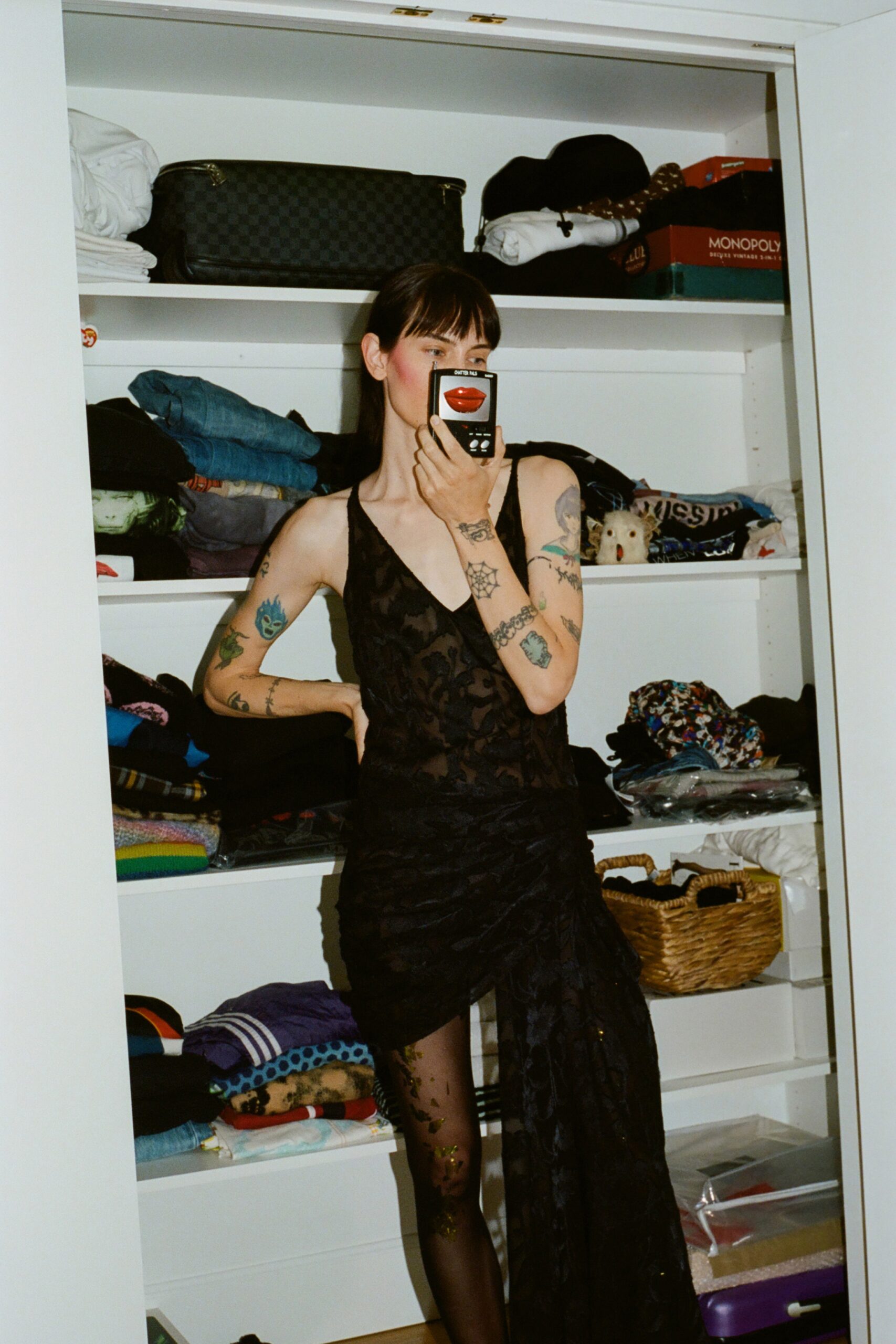 A fitted black lace sleeveless dress with a V-neckline and asymmetric design.