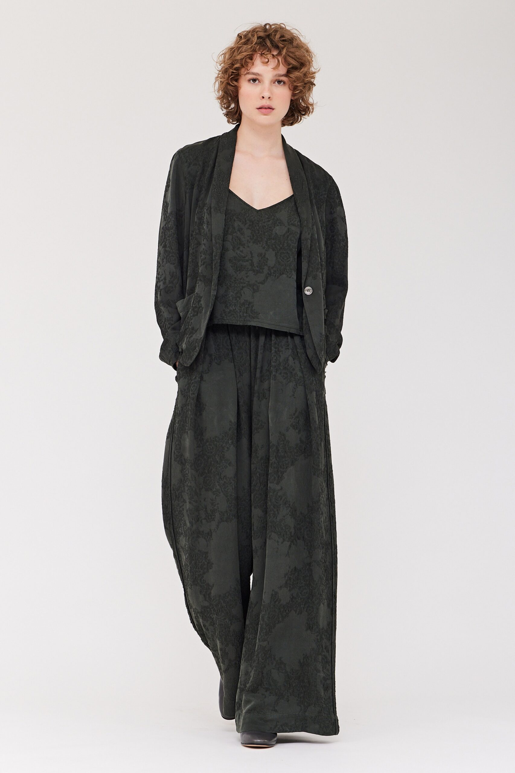 A relaxed black printed jacket paired with matching pants featuring a V-neckline.