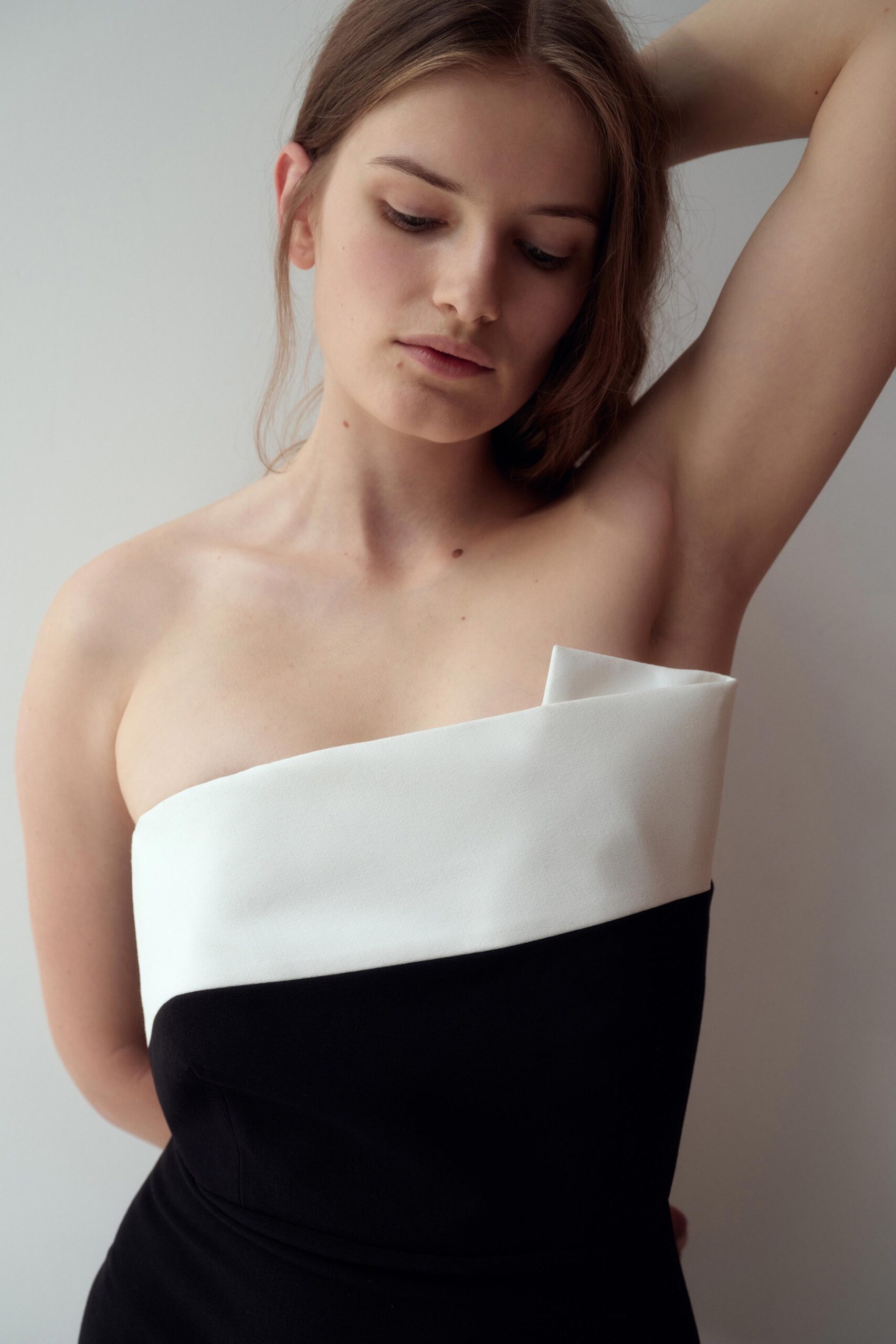 A fitted black and white strapless dress with an asymmetric design detail.