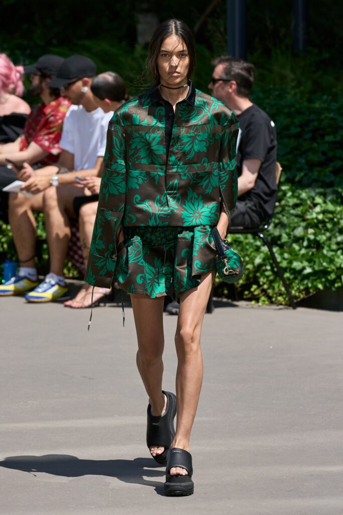 A relaxed green and black floral dress with long sleeves and a collared neckline.