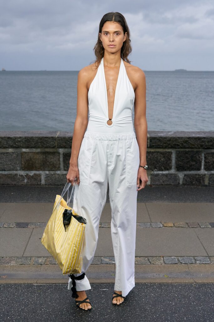 A relaxed white cotton sleeveless jumpsuit with a deep V-neckline and wide-leg silhouette.