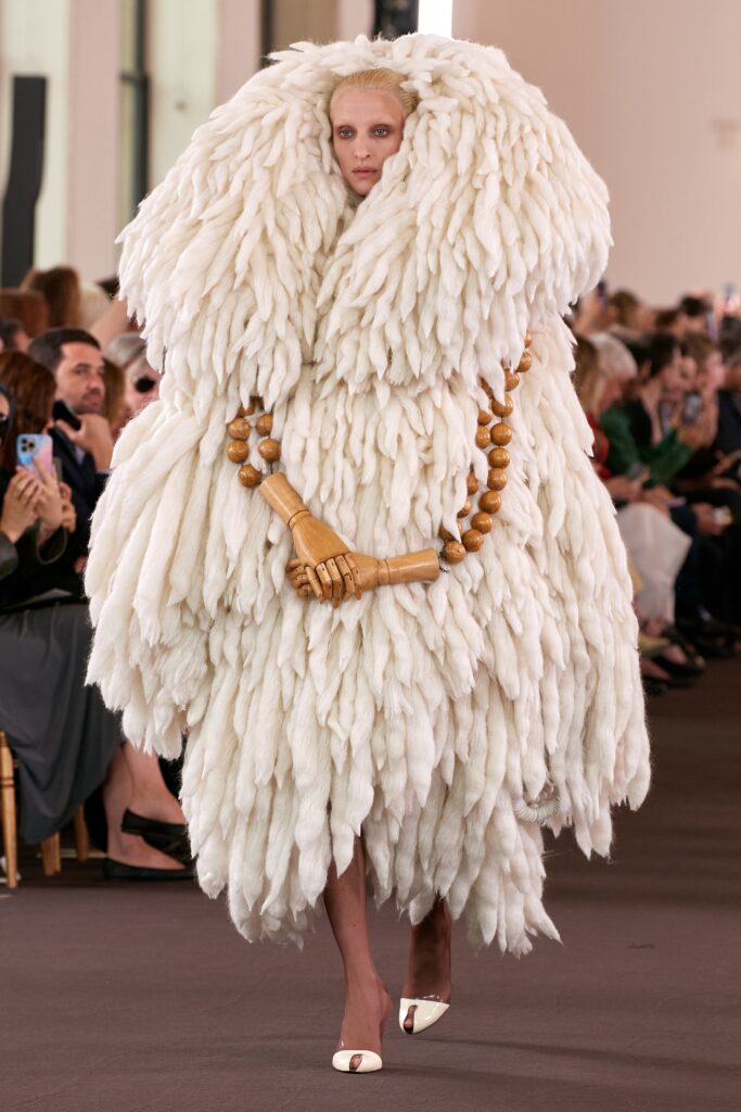 An oversized white fur coat with long sleeves and a layered design.