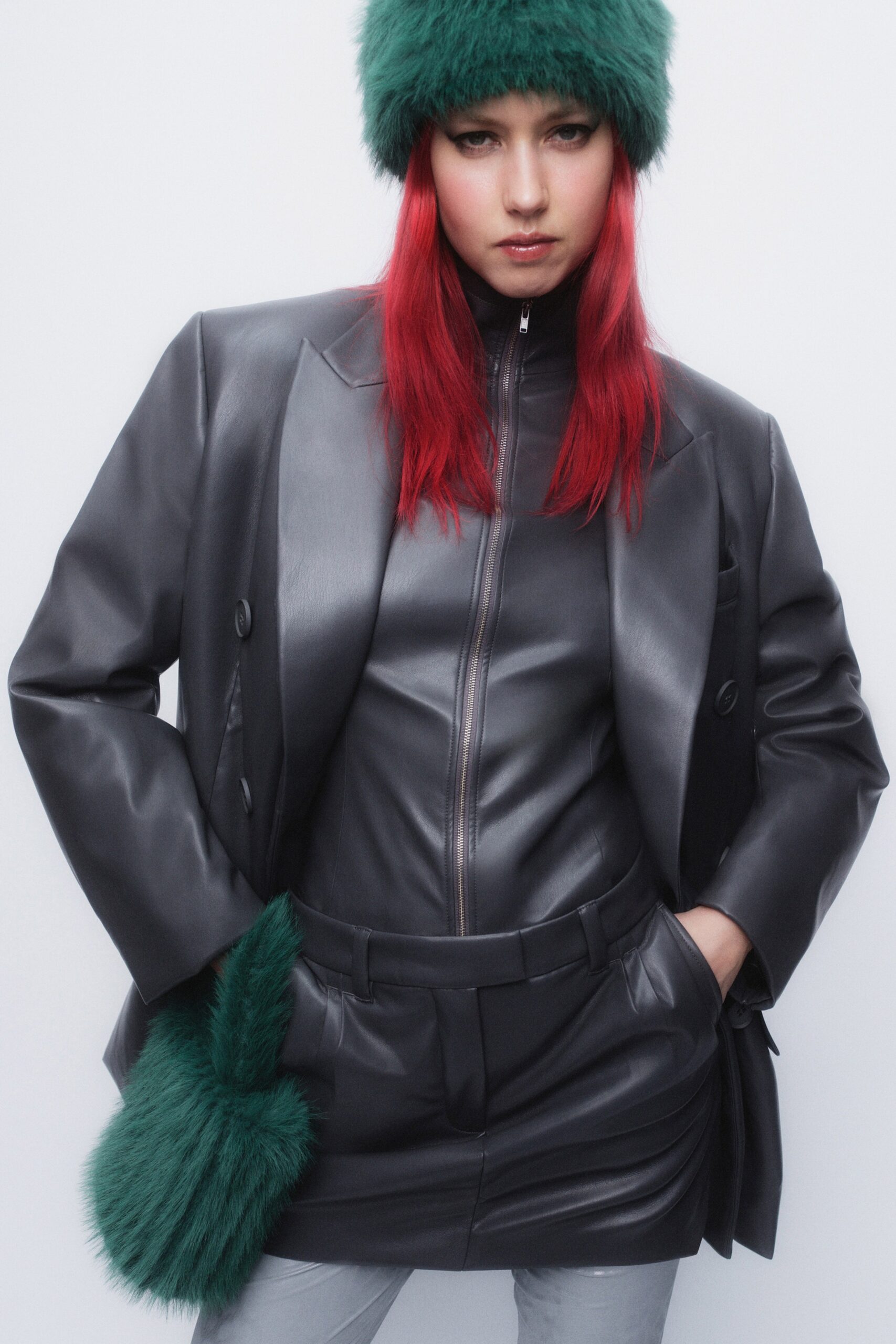 A fitted black leather jacket with a high-neck and structured design.