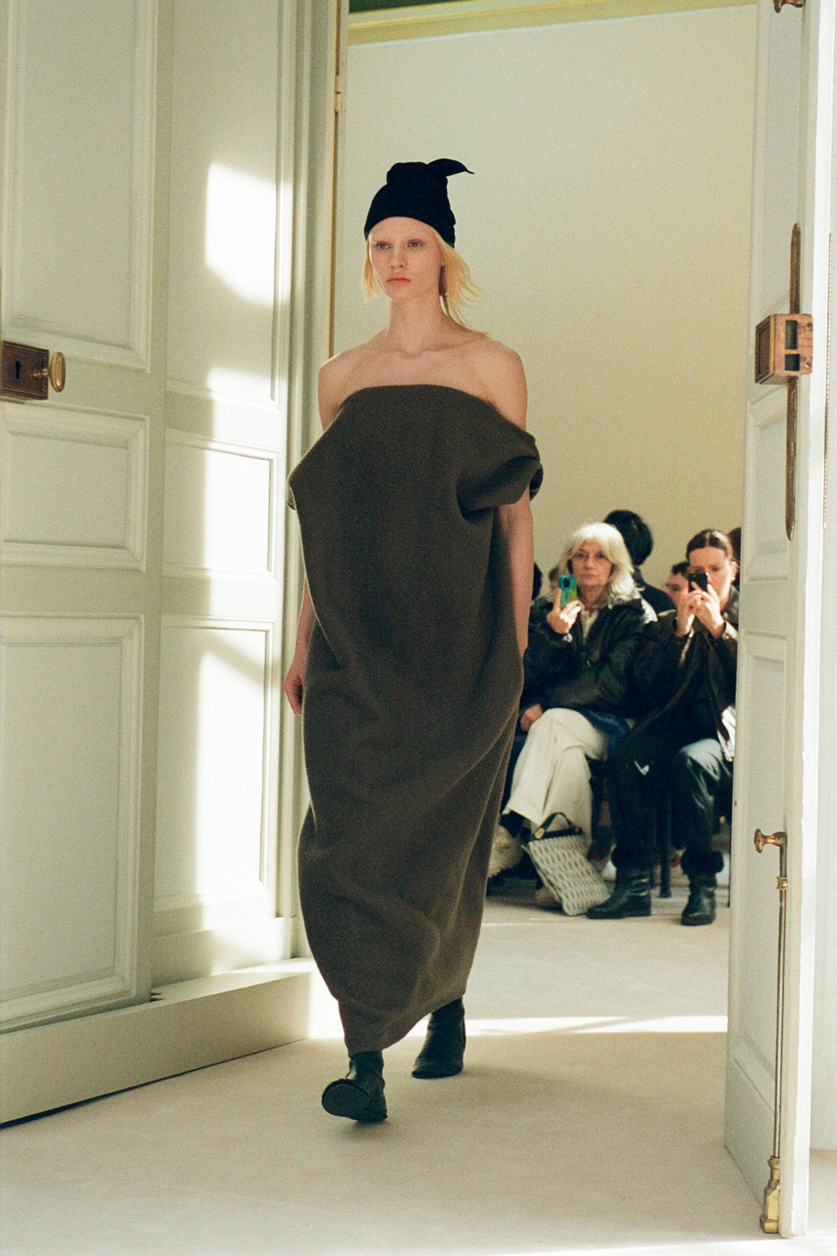An oversized brown strapless dress made of wool with a maxi silhouette.