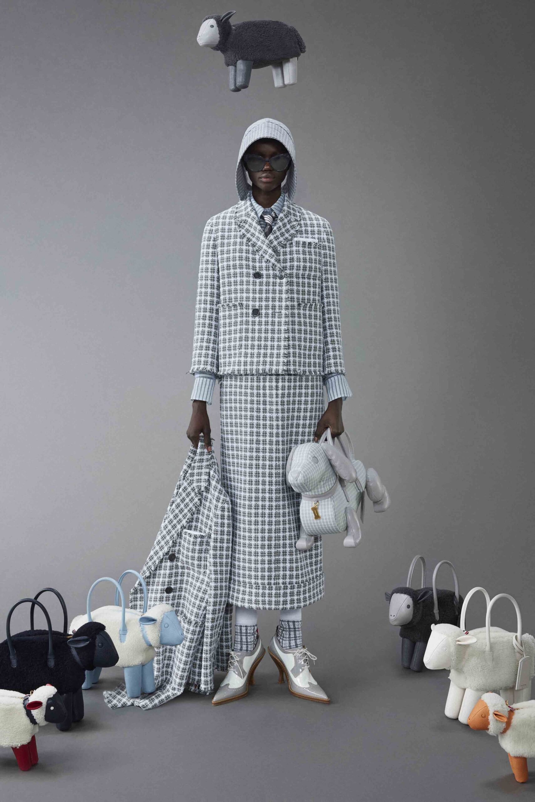 A fitted gray and white checked jacket with a collared neckline paired with a matching skirt.