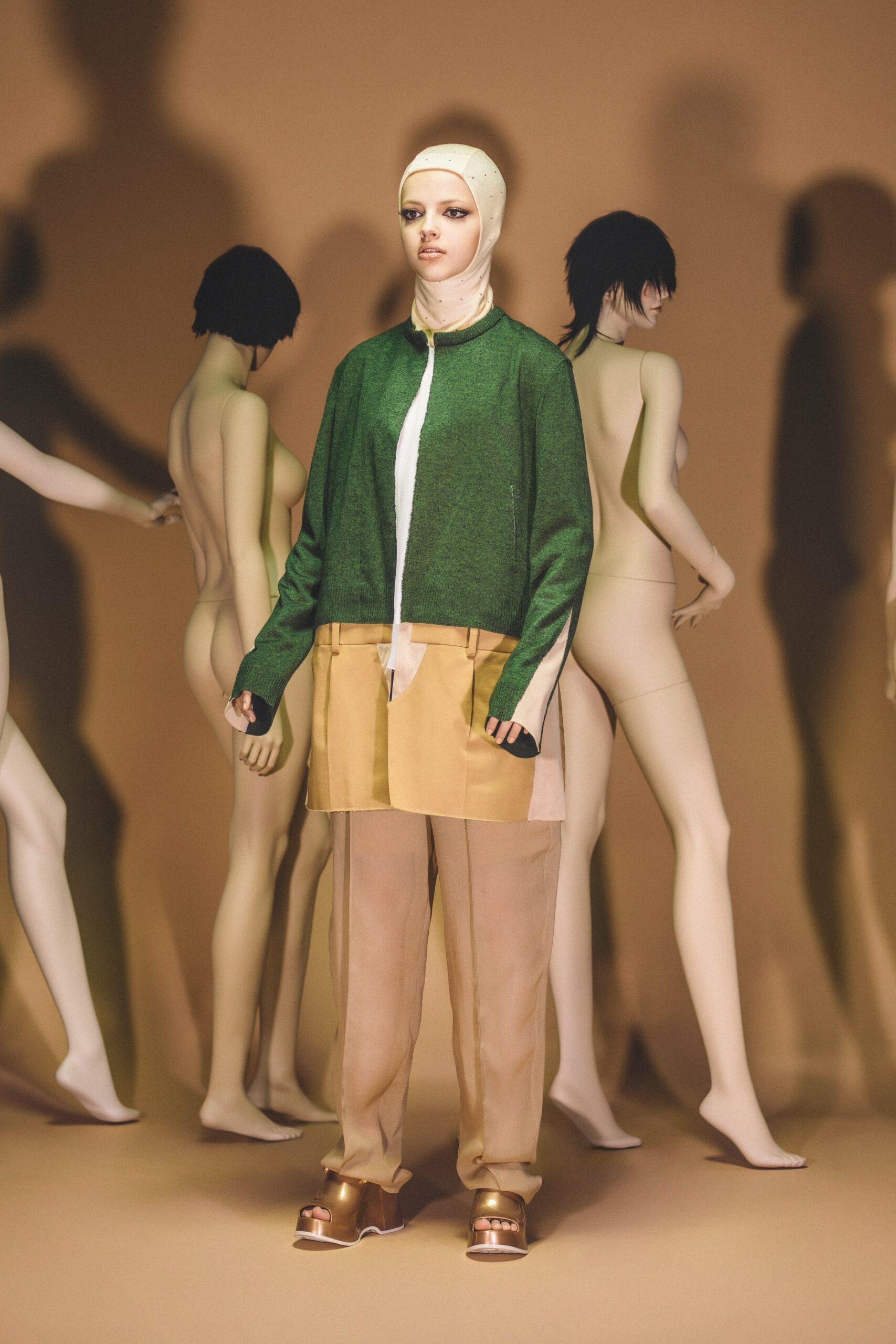 A relaxed green cotton jacket paired with beige pants, featuring a long-sleeve and collared design.