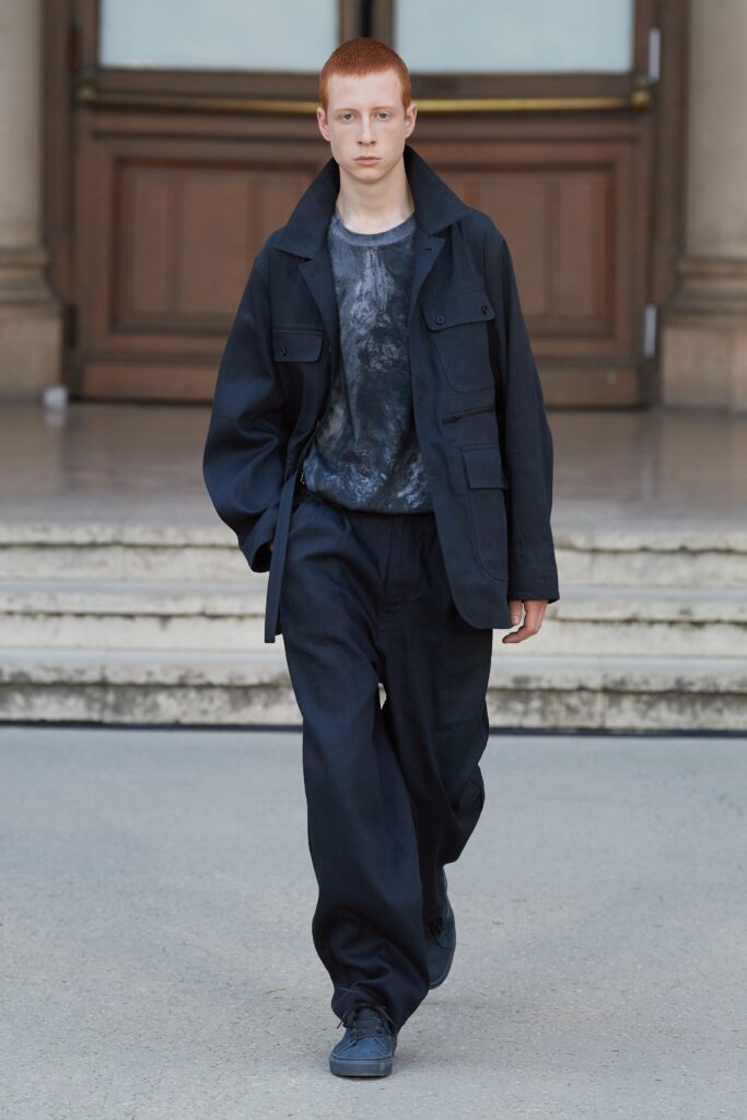 A relaxed black cotton jacket with long sleeves and collared design paired with straight-leg pants.