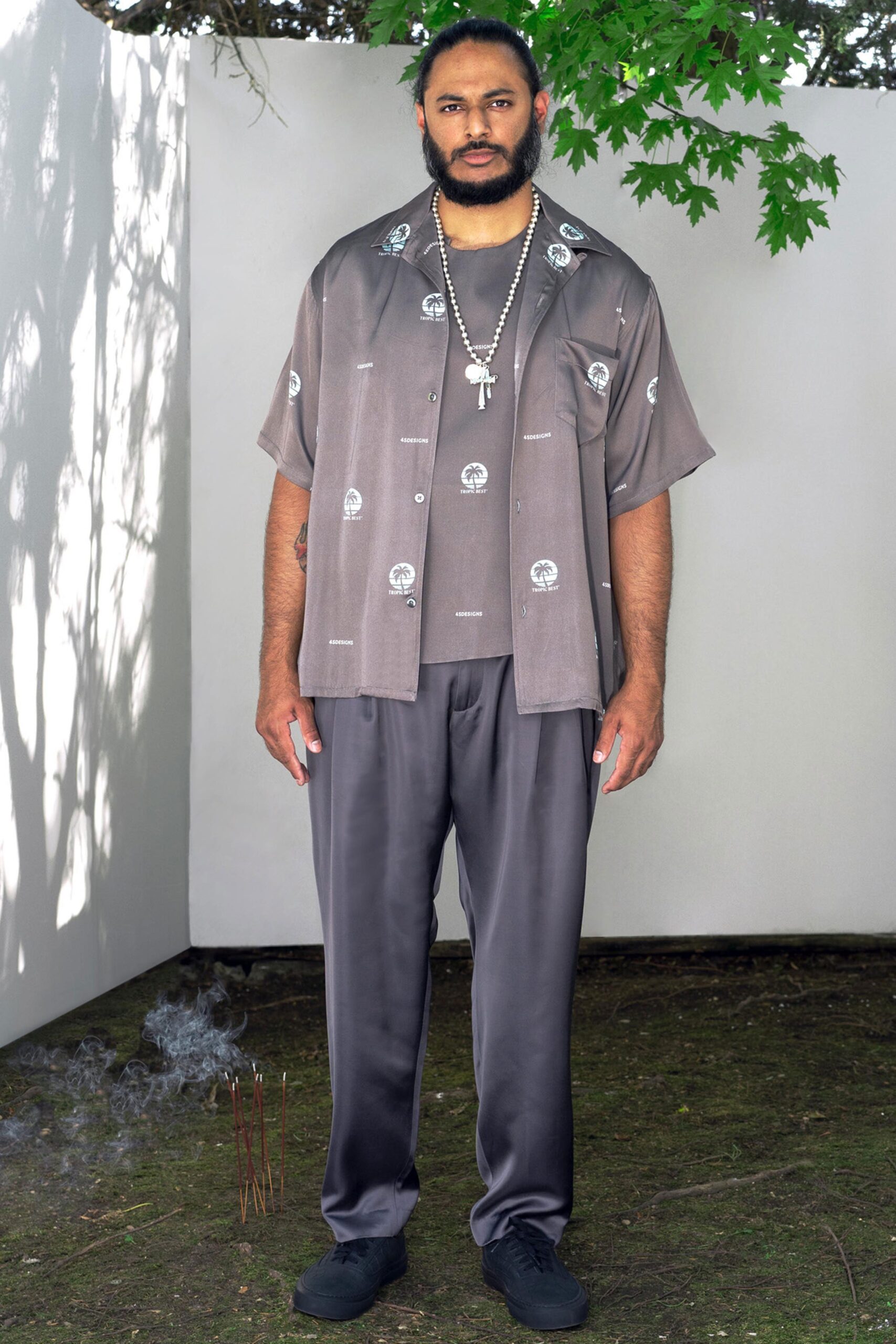A relaxed gray silk shirt with a collared neckline and printed design, paired with matching pants.