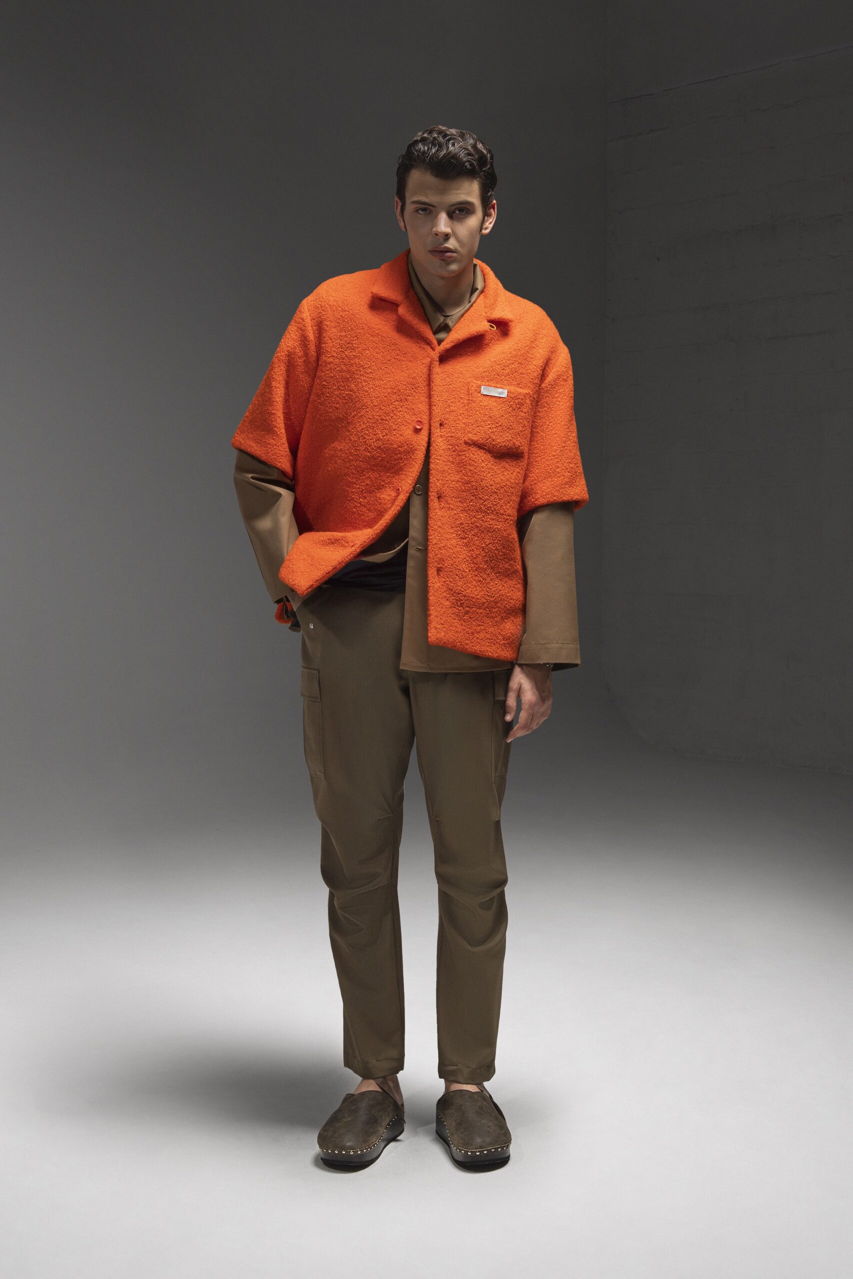 A relaxed orange cotton short-sleeve jacket paired with brown pants.