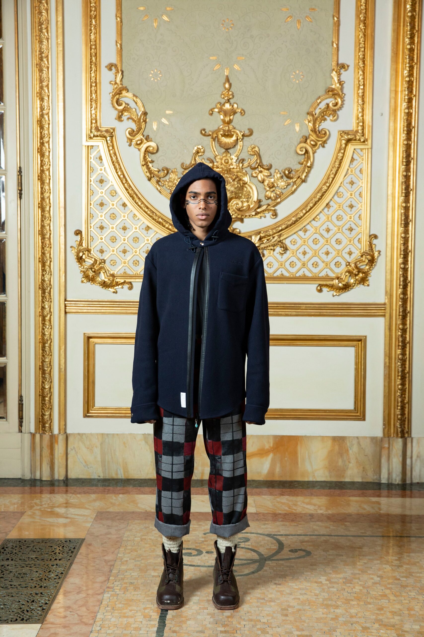 An oversized black hooded jacket paired with checked pants for a stylish look.
