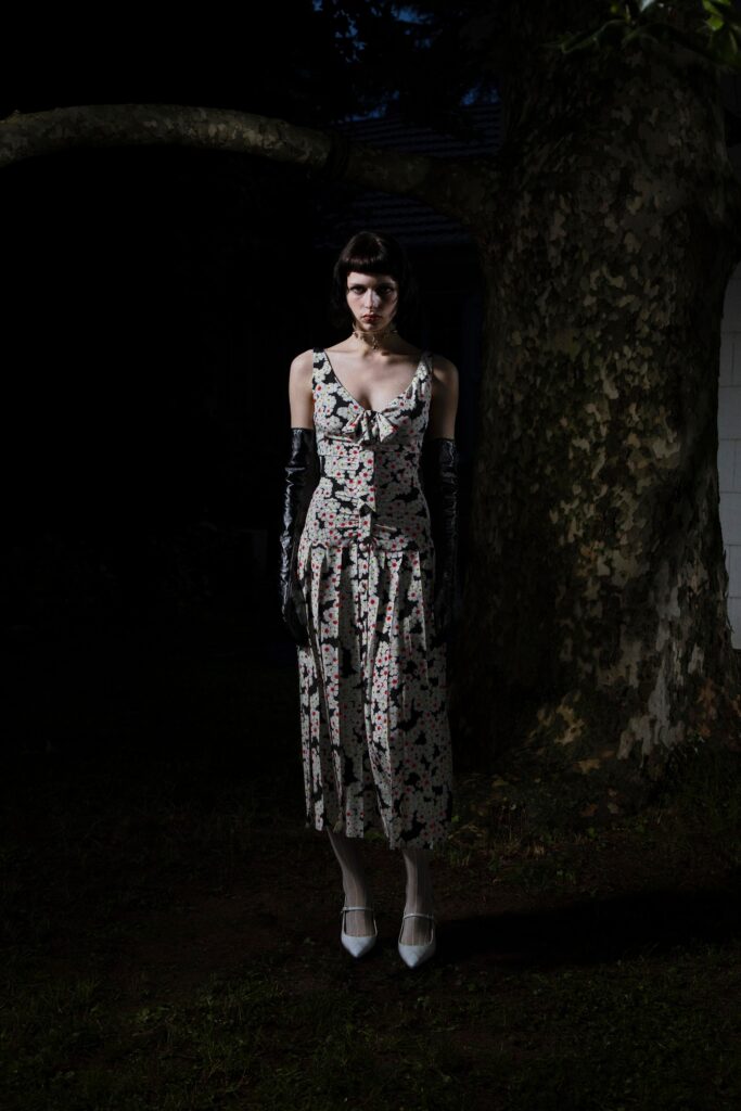 A fitted black and white dress with a V-neckline and flared silhouette.