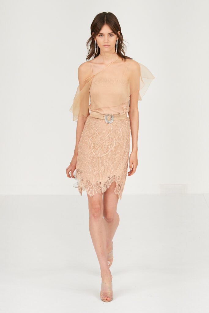 A fitted beige silk off-shoulder dress with embroidered details and a tiered design.