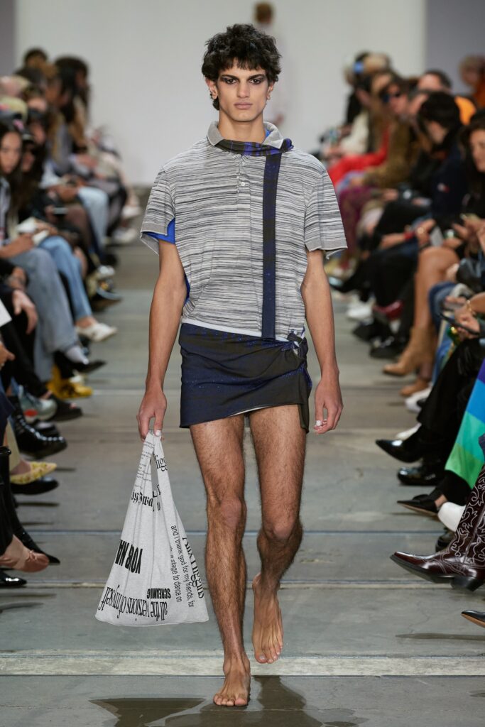 A relaxed gray striped short-sleeve top paired with blue shorts featuring an asymmetric design.