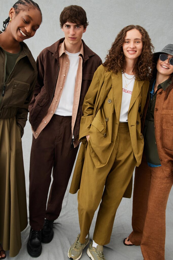 A relaxed brown cotton jacket with long sleeves and collared design paired with wide-leg pants.