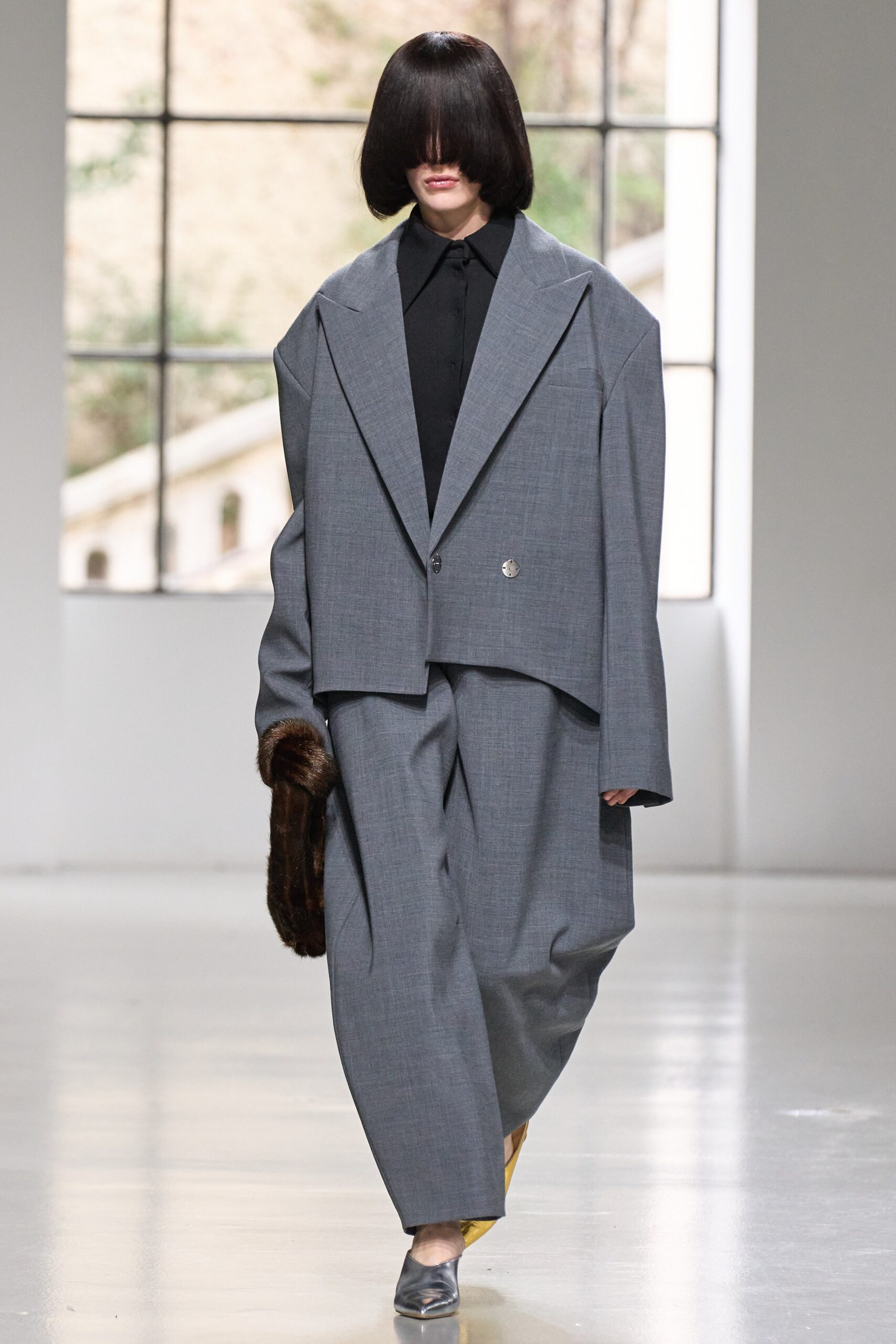An oversized gray wool jacket with a collared neckline and asymmetric design paired with matching pants.