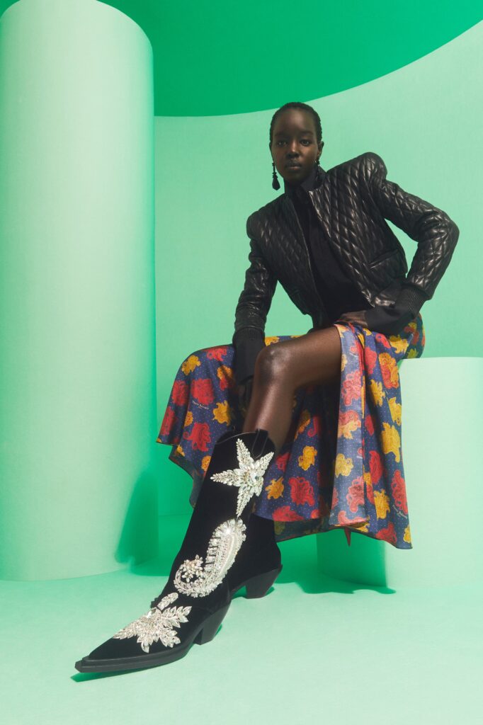 A fitted black leather jacket paired with a flared multicolor dress.
