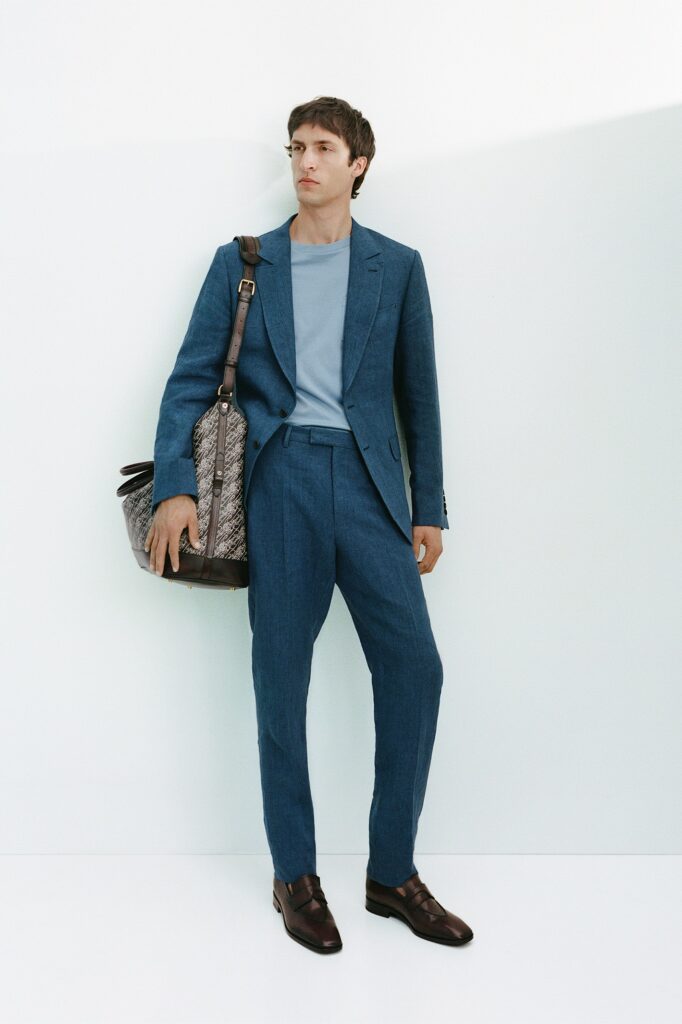 A tailored blue cotton suit with long sleeves and a collared shirt, featuring straight-leg trousers.