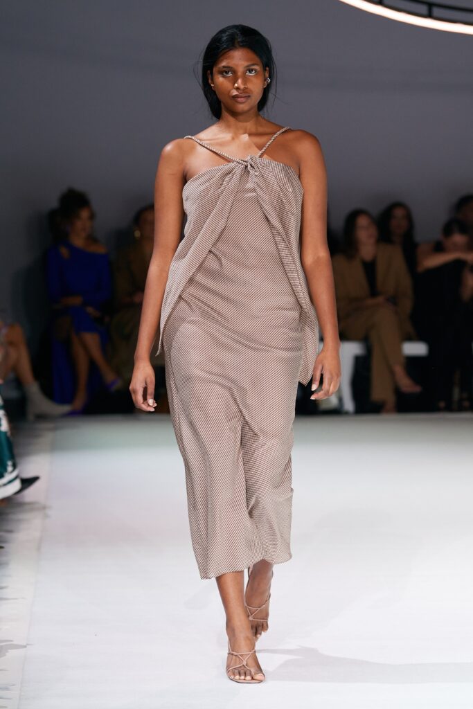 A relaxed beige silk sleeveless dress with a V-neckline and asymmetric design.
