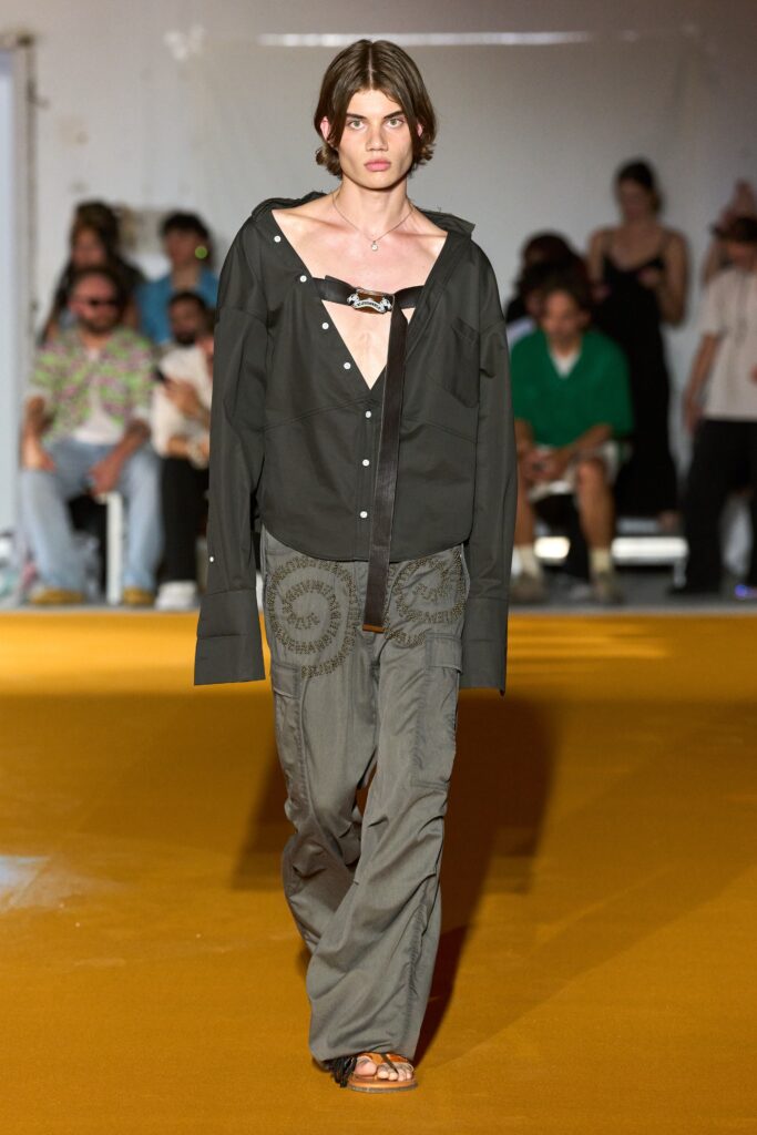 A relaxed black long-sleeve collared shirt paired with gray embroidered pants.
