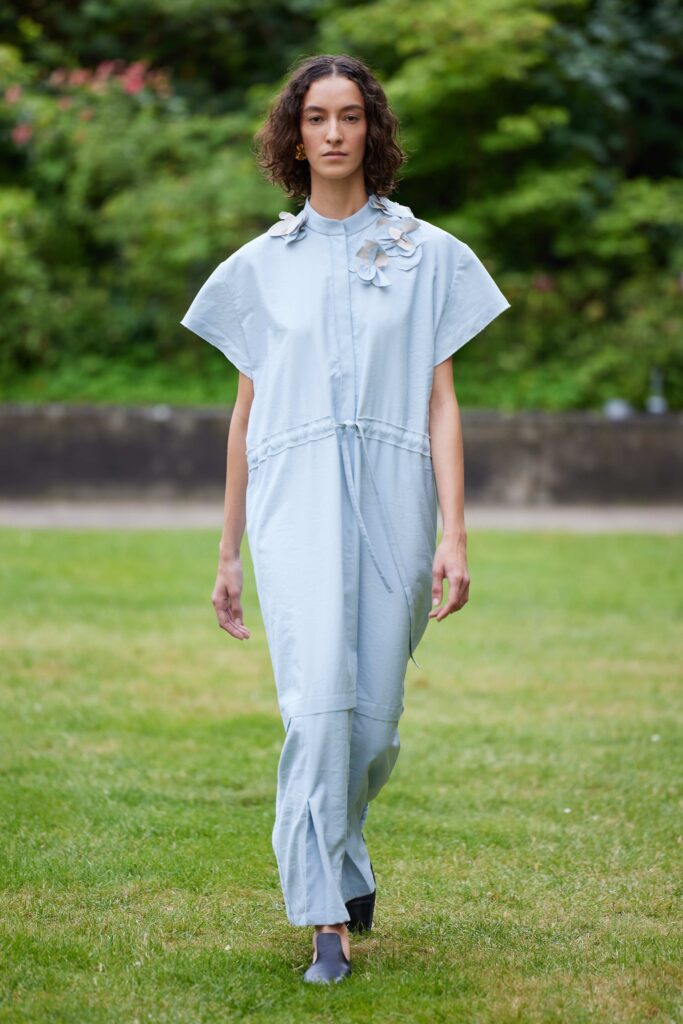 An oversized blue cotton dress featuring a unique floral detail and long sleeves.