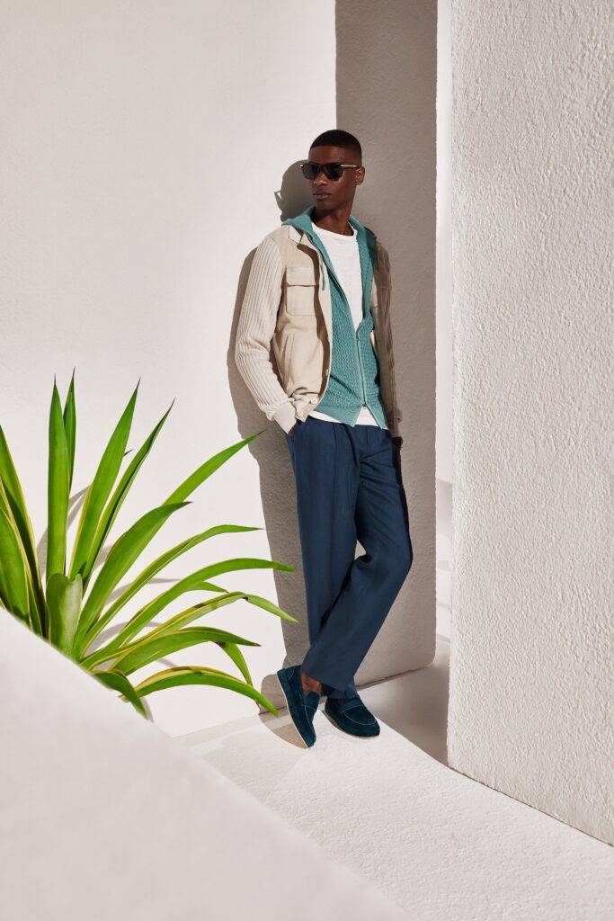 A relaxed beige jacket layered over a white collared shirt, paired with blue trousers.