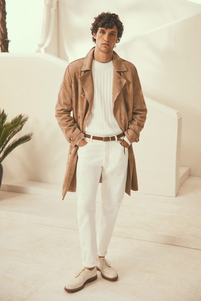 A fitted beige suede coat layered over a white long-sleeve sweater, creating a stylish look.