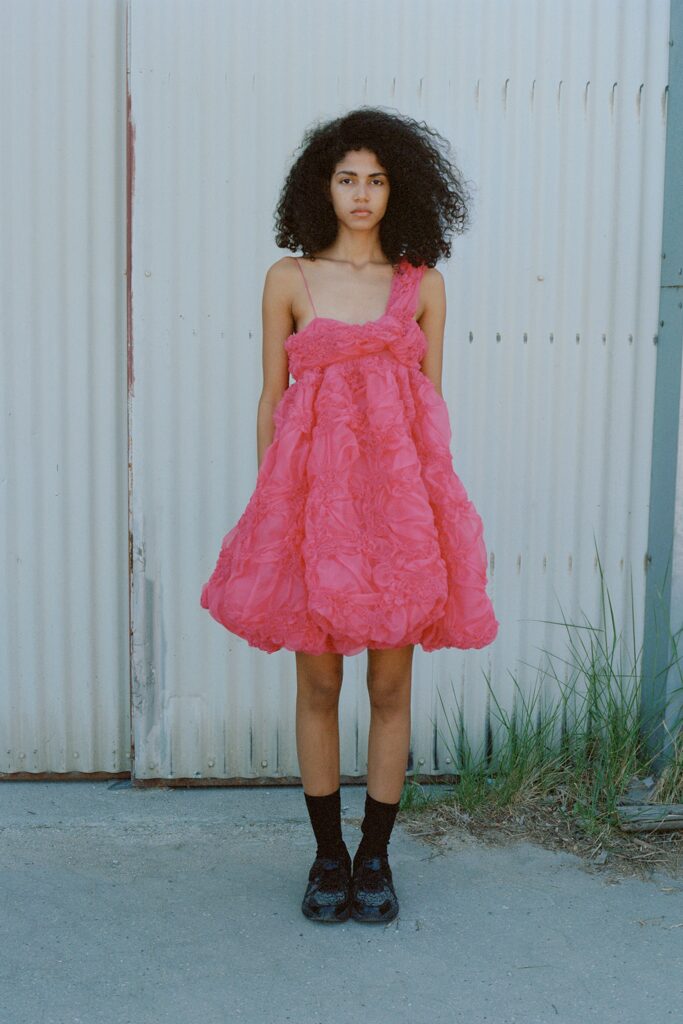 A relaxed pink tulle sleeveless dress with a tiered design.