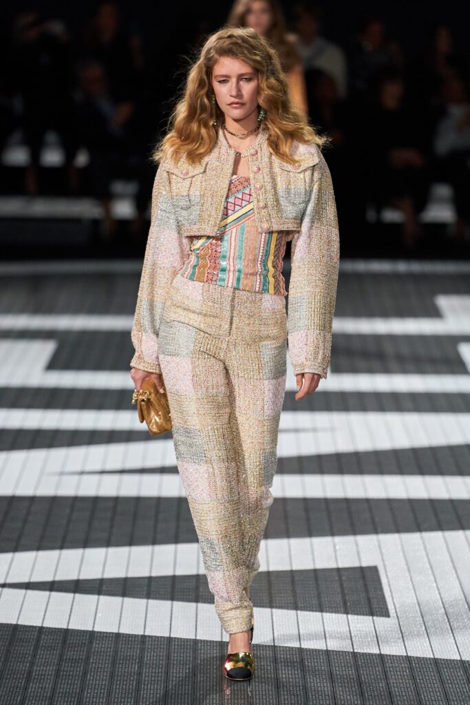A fitted multicolor tweed jacket with long sleeves and collared design, paired with matching pants.