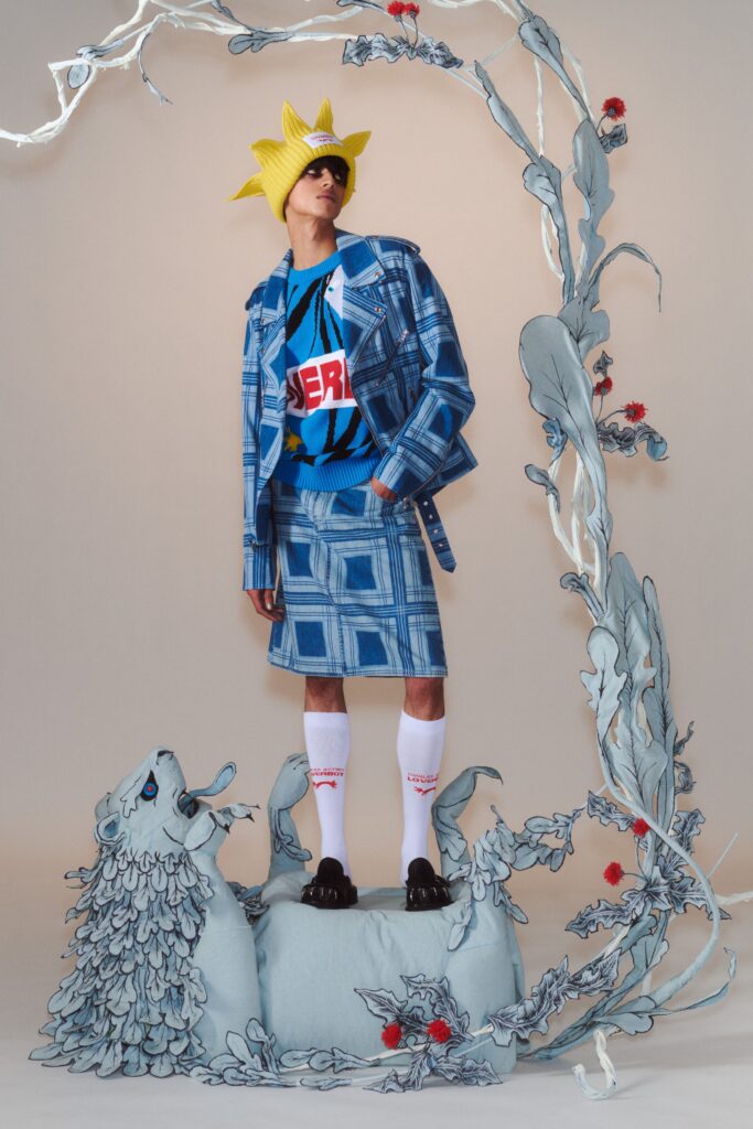 A fitted blue denim jacket with a collared neckline paired with a checked denim skirt.