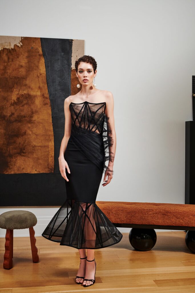 A fitted black silk dress with a sleeveless design and tiered silhouette.