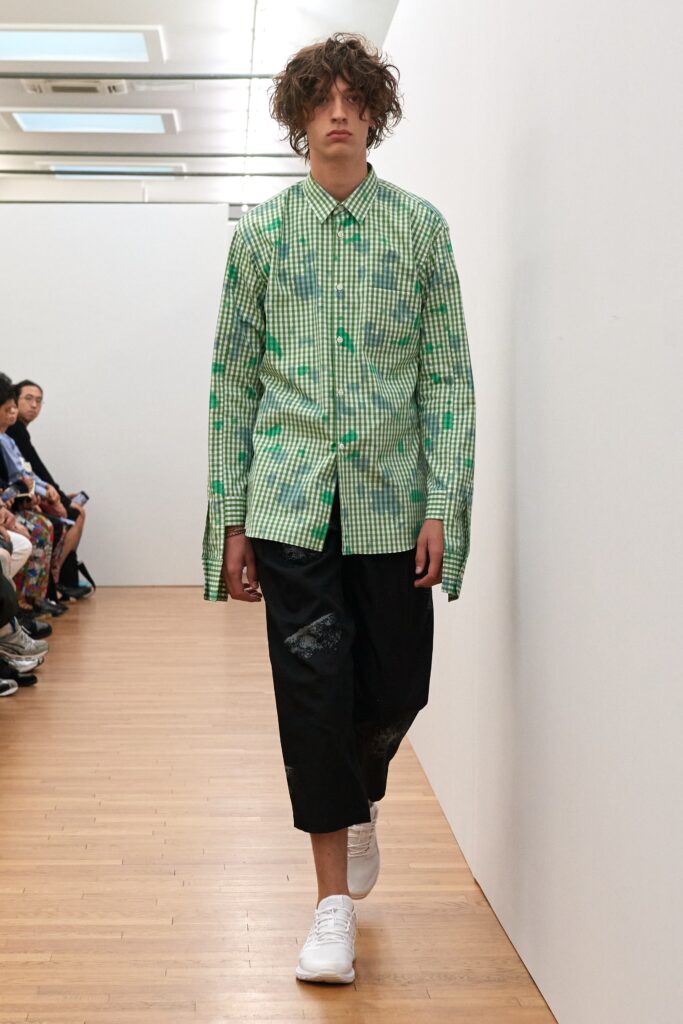 A relaxed-fit green checked shirt with long sleeves paired with black pants.
