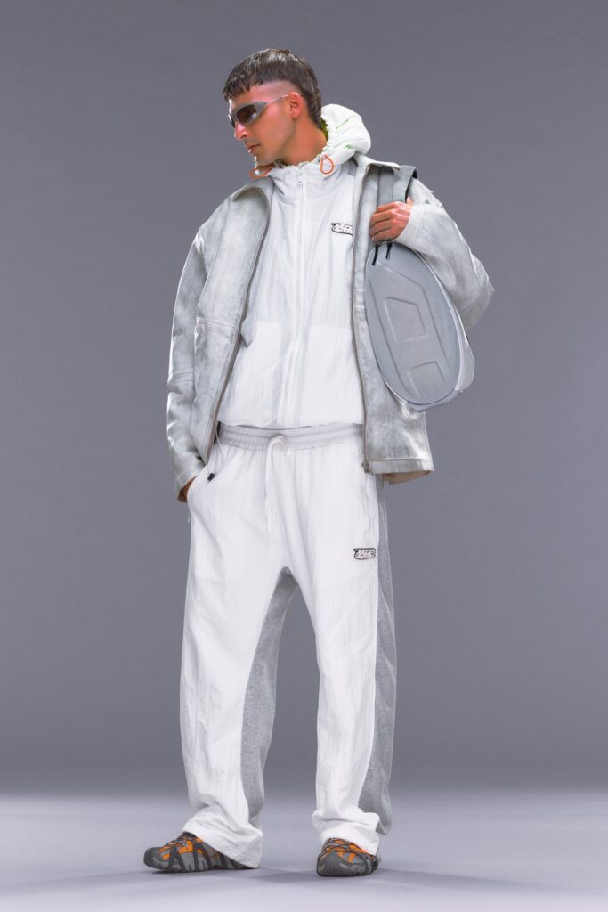 A relaxed fit gray and white jacket with hood and matching pants, featuring zippered and buttoned details.