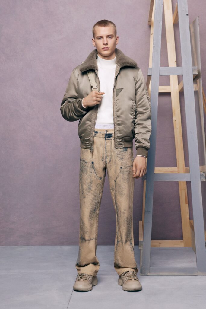 An oversized beige jacket paired with gray denim pants for a contemporary streetwear look.