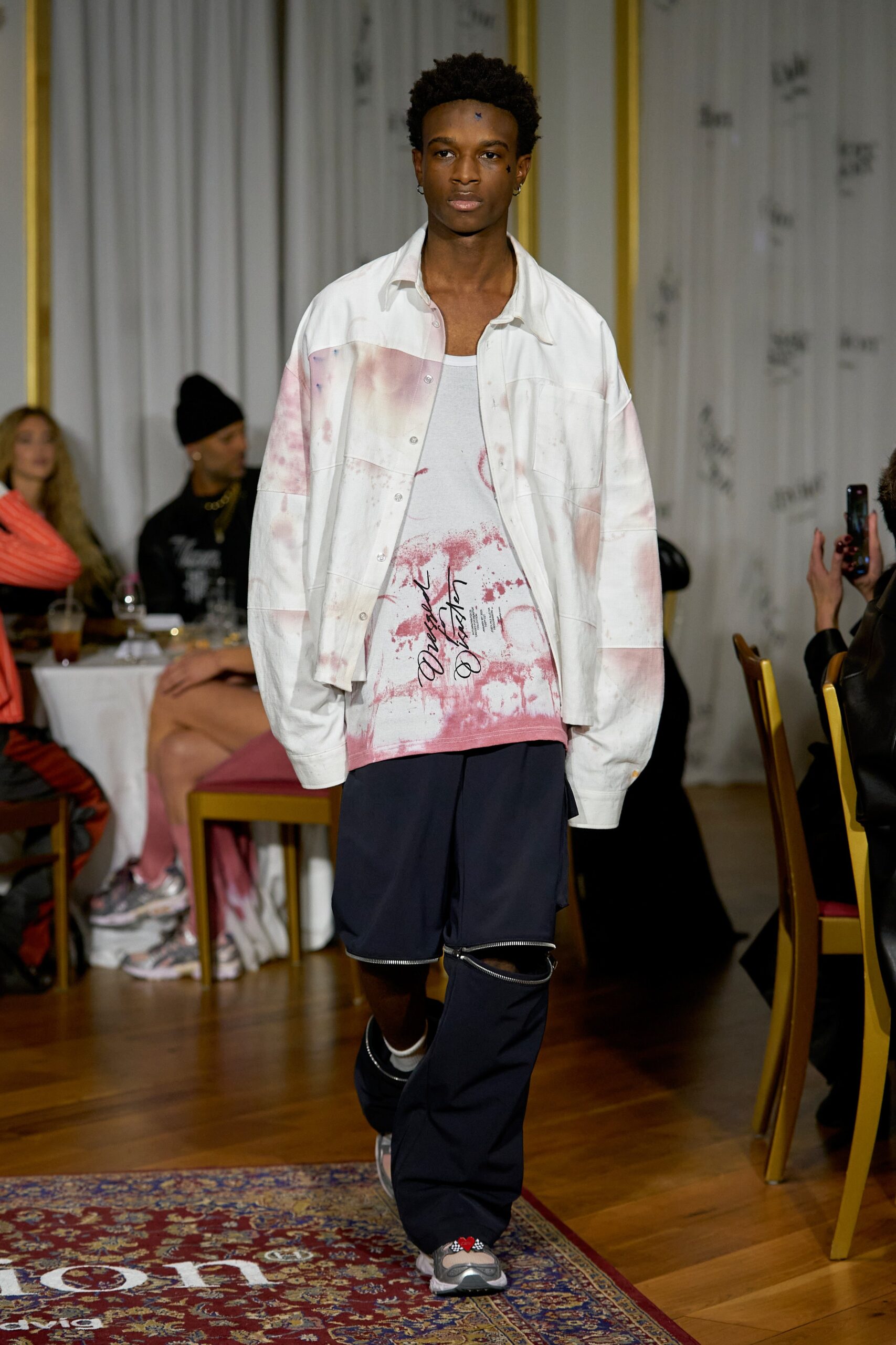 A relaxed white printed jacket paired with a sleeveless tank-top in pink and black.