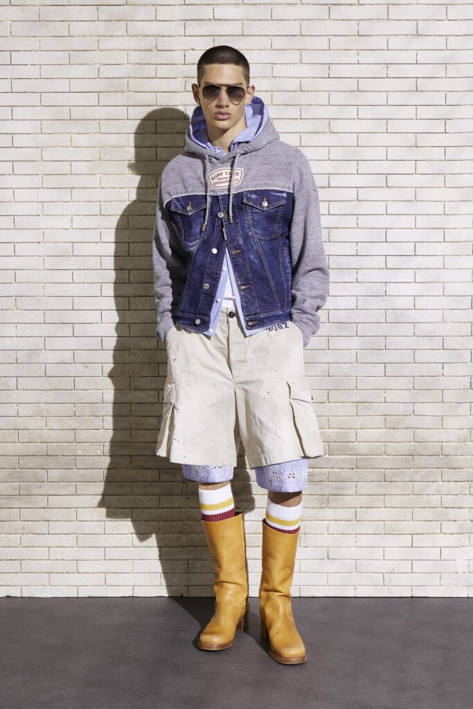 An oversized blue denim jacket paired with beige cotton shorts and stylish knee-high boots.