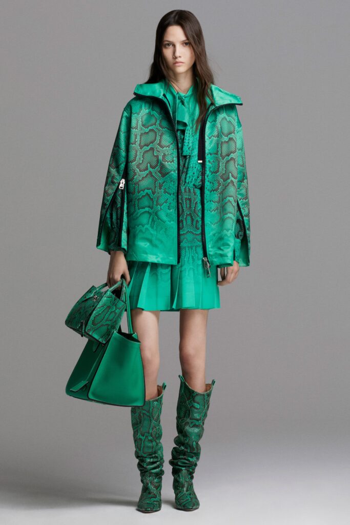 A fitted green printed coat layered over a matching dress with a collared neckline.