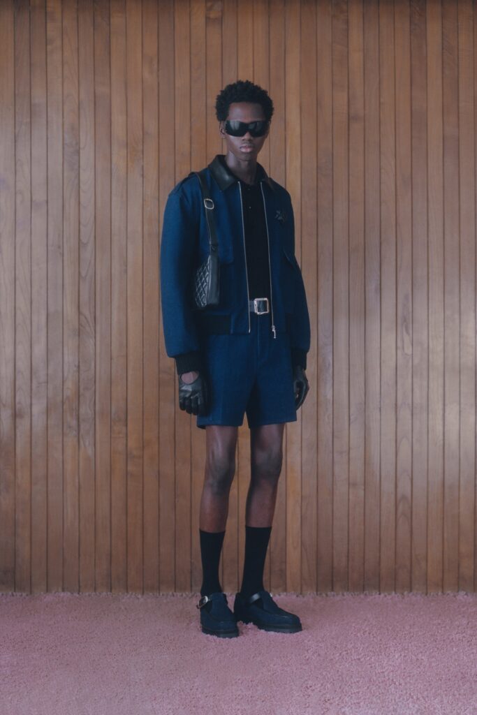 A fitted navy jacket with short sleeves and matching shorts, featuring a collared design.